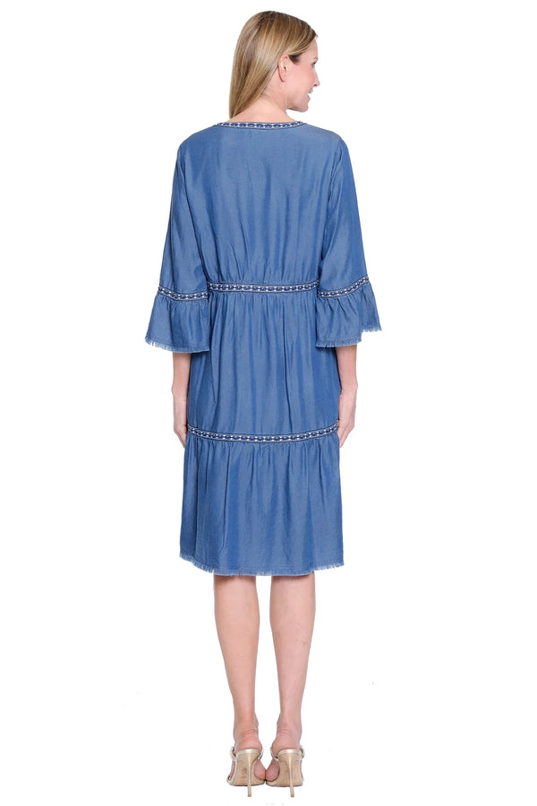Woman wearing a blue dress with ruffled sleeves on a white background