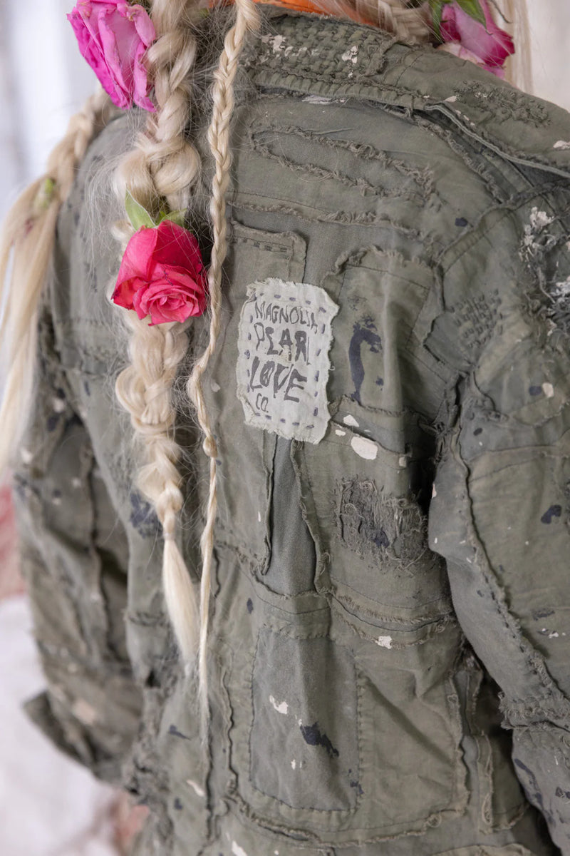 Woman wearing olive green button up jacket with patches all over