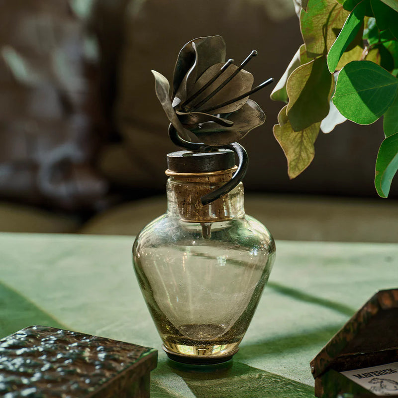 Glass vase with cast iron flower sticking out