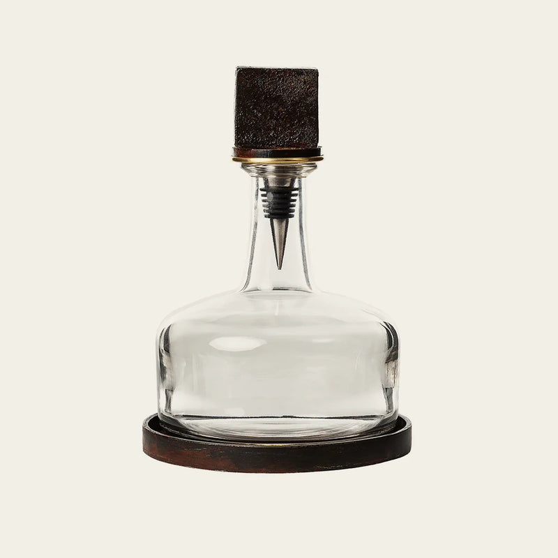 Glass decanter with cast iron base with cast iron cube on the top 