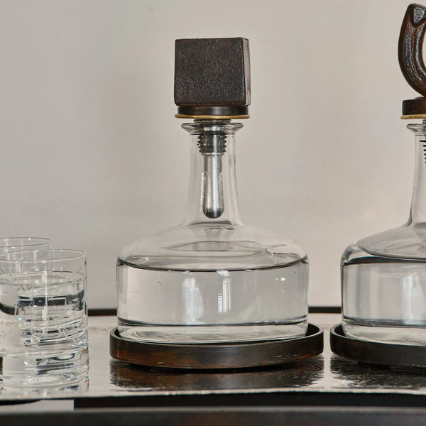 Glass decanter with cast iron base with cast iron cube on the top
