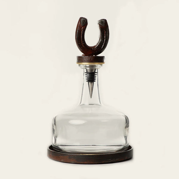 Glass decanter with cast iron base and cast iron horse shoe top