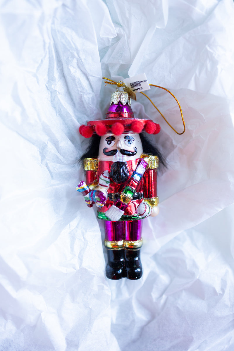 Mexican nutcracker Christmas ornament holding colorful Pinata hanging on Christmas tree