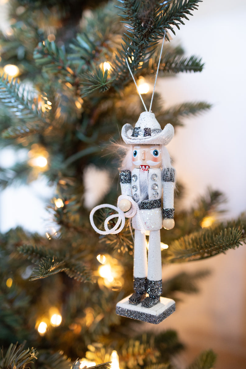 WOODEN COWBOY NUTCRACKER ORNAMENT HOLDING A LASSO HANGING OFF A CHRISTMAS TREE