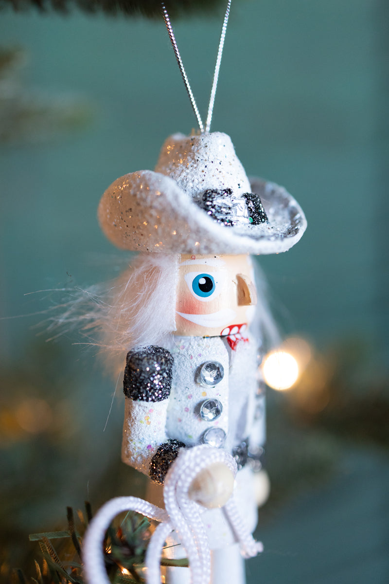 WOODEN COWBOY NUTCRACKER ORNAMENT HOLDING A LASSO HANGING OFF A CHRISTMAS TREE