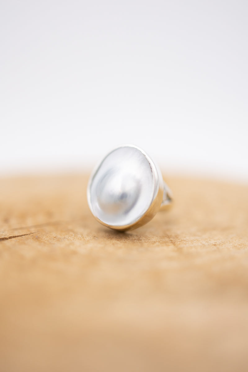Blister pearl ring with sterling silver bezel on wooden display