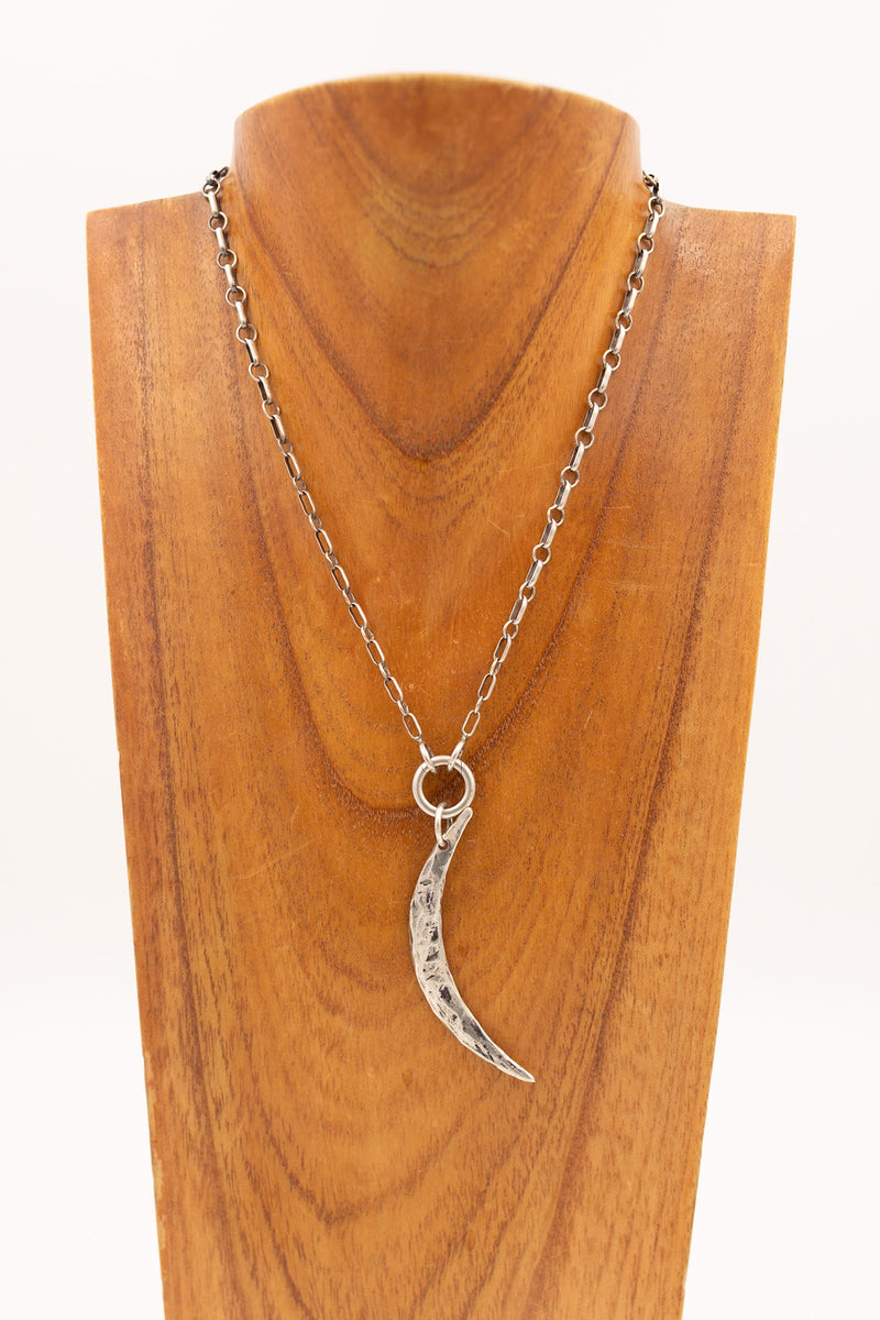 Sterling silver hammered crescent moon charm on display necklace