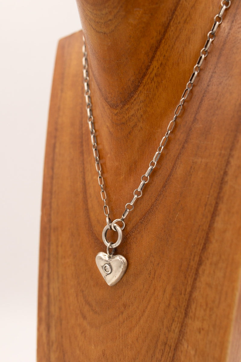 Sterling silver heart charm with cubic zirconia in the center.