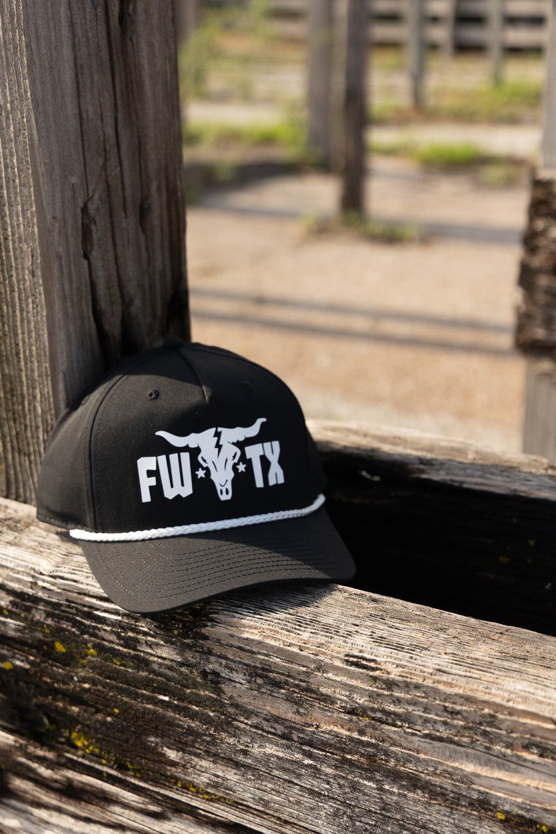 Black cap with white logo and text on a wooden surface