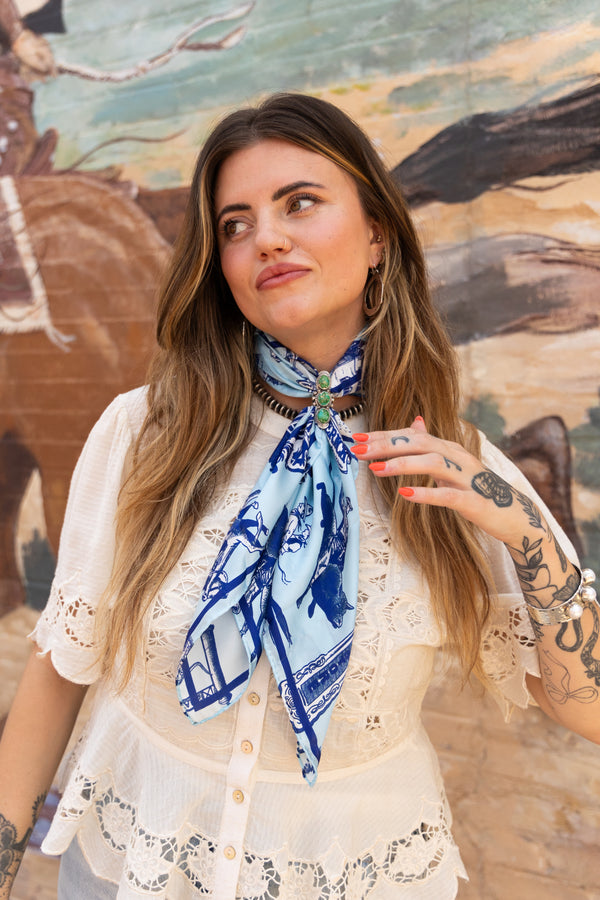 Woman wearing a blue scarf in front of a mural