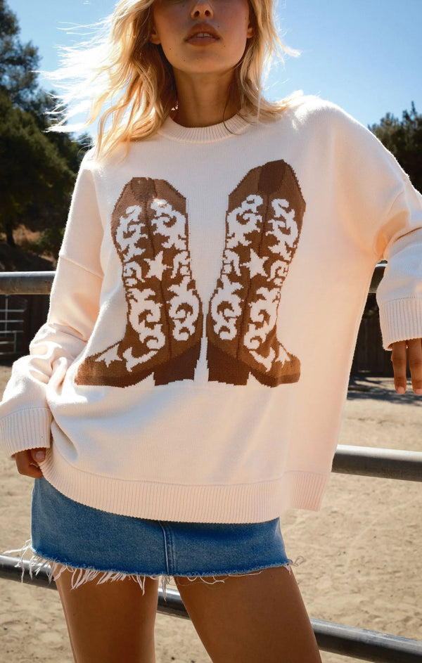Person wearing a sweater with cowboy boot design outdoors