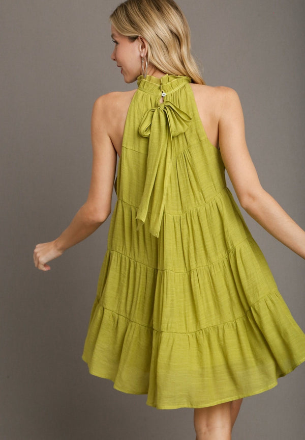 Green halter tiered dress with button on the neck and bow on the back