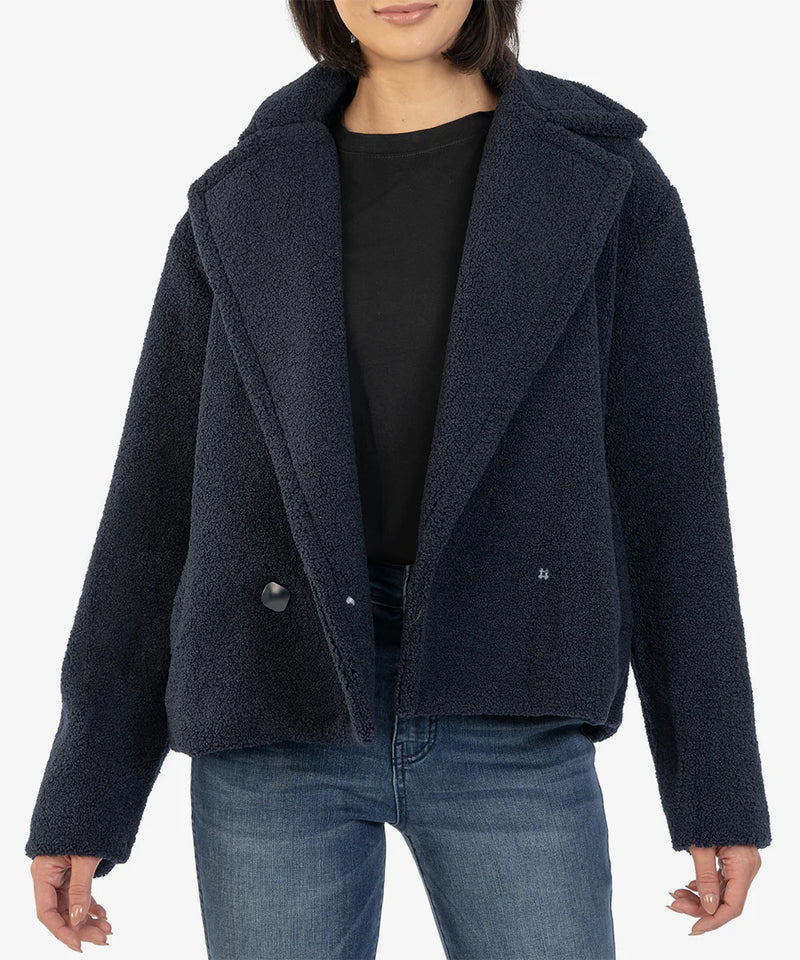 Woman wearing navy coat with statement collar 