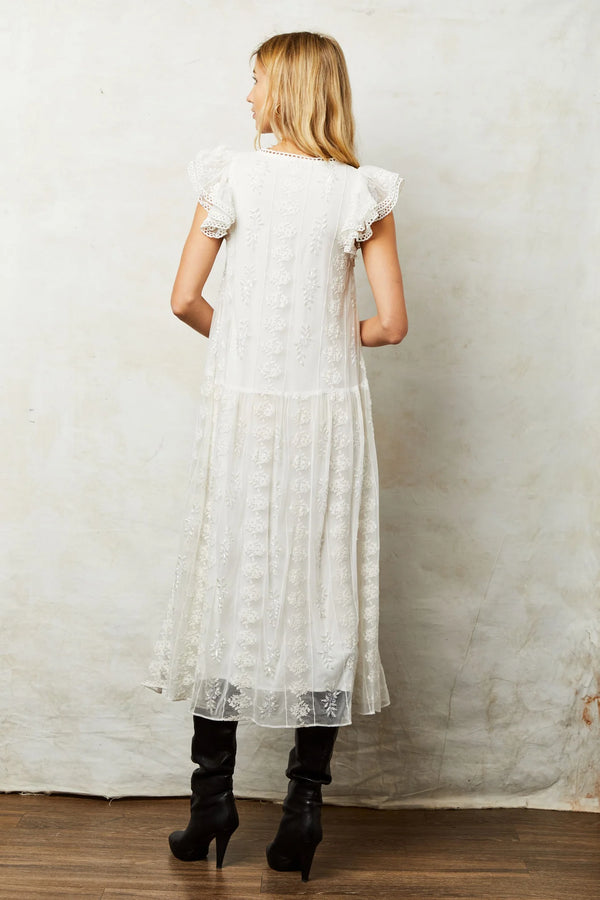 Woman wearing beaded white dress with cup sleeves and midi length
