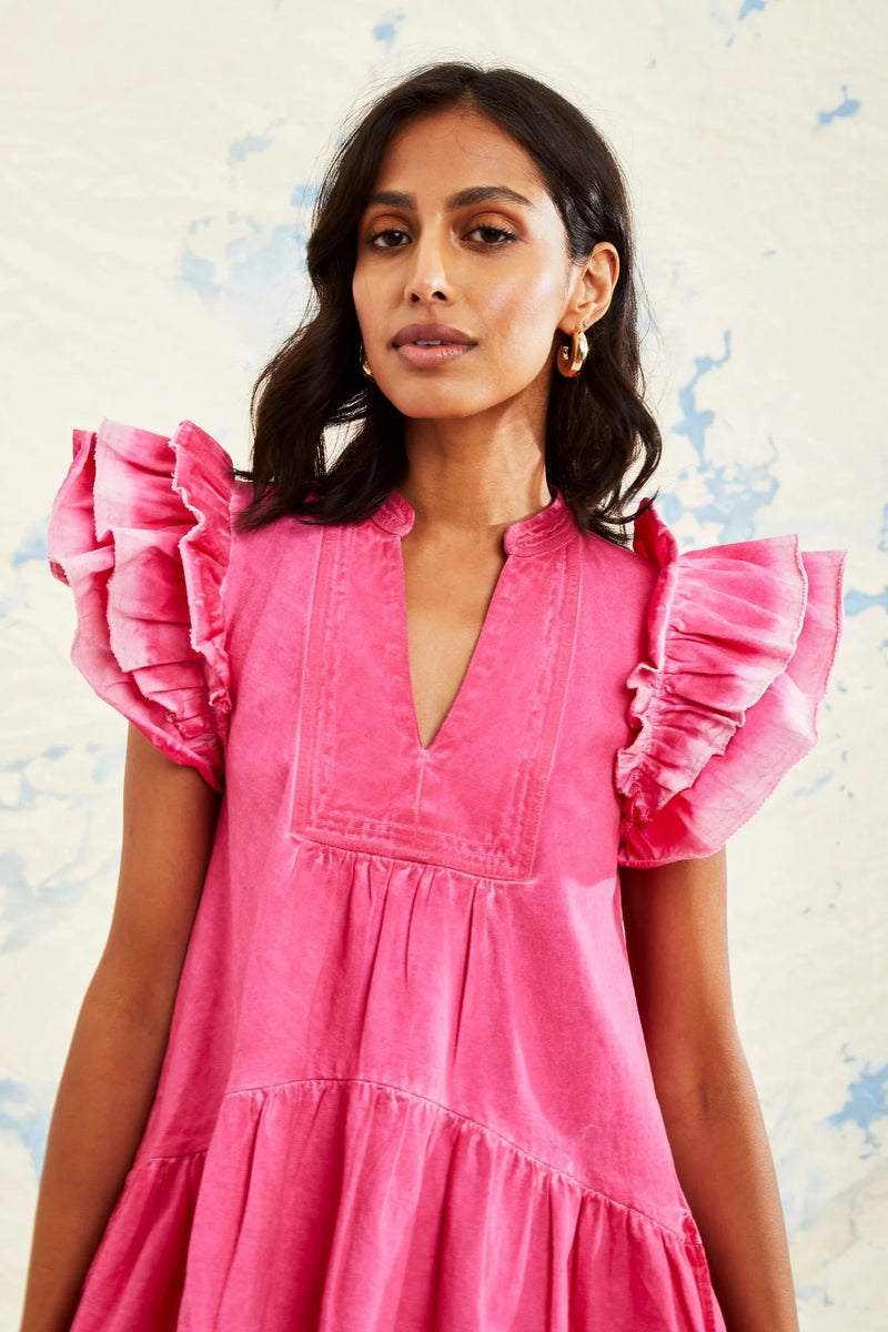 WOMAN WEARING PINK TIERED DRESS WITH RUFFLE SLEEVES