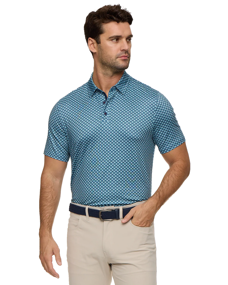 Man wearing a blue patterned polo shirt and beige pants on a white background