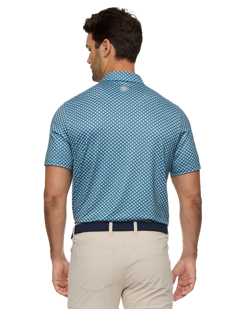 Man wearing a blue patterned shirt and beige pants on a white background