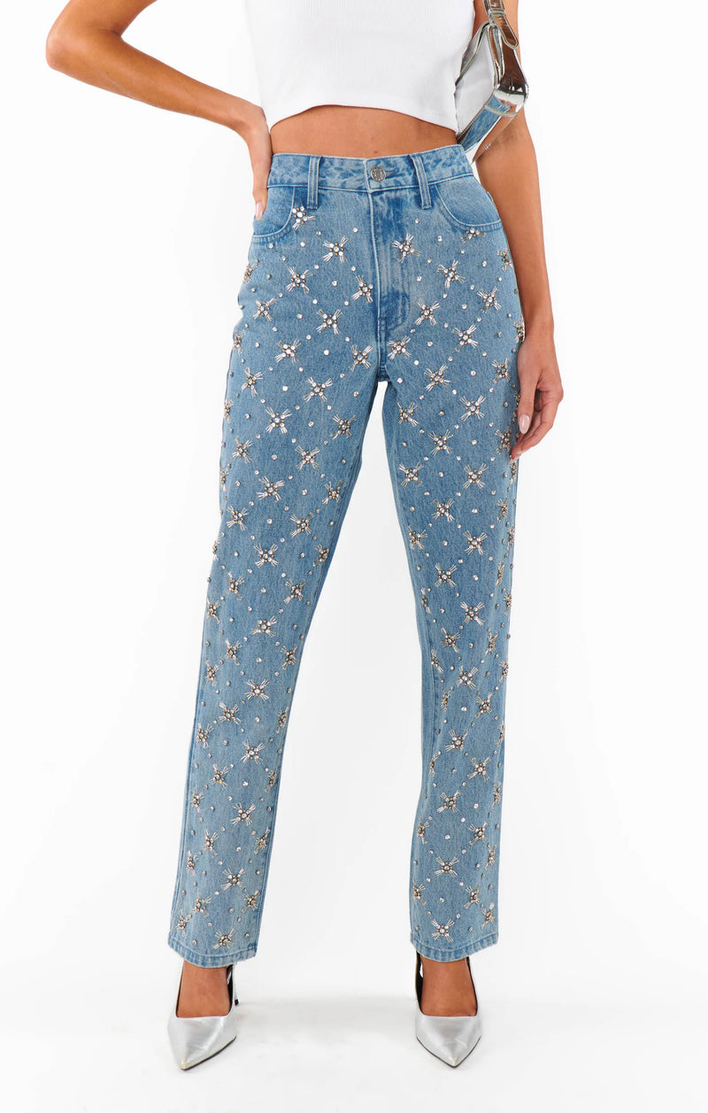 Blue jeans with star pattern worn by a person on a white background