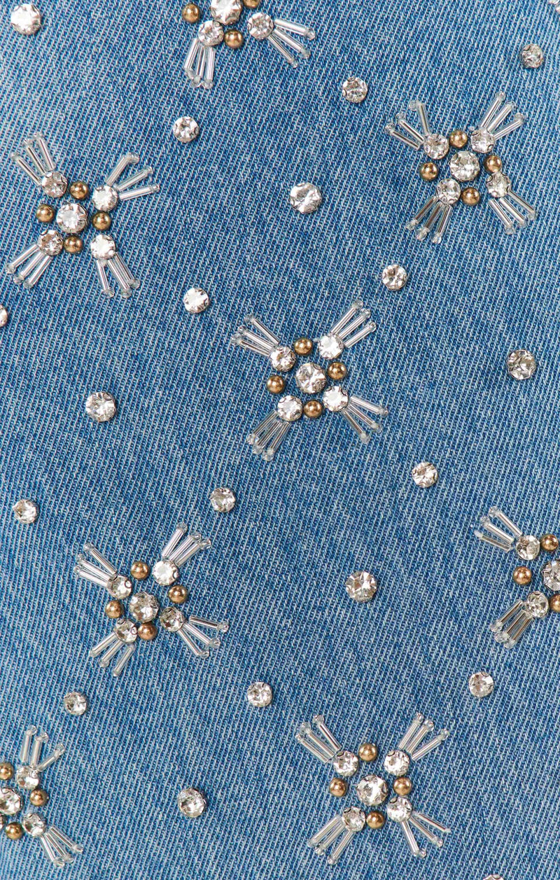 Close-up of a denim fabric with embroidered snowflakes and crystals.