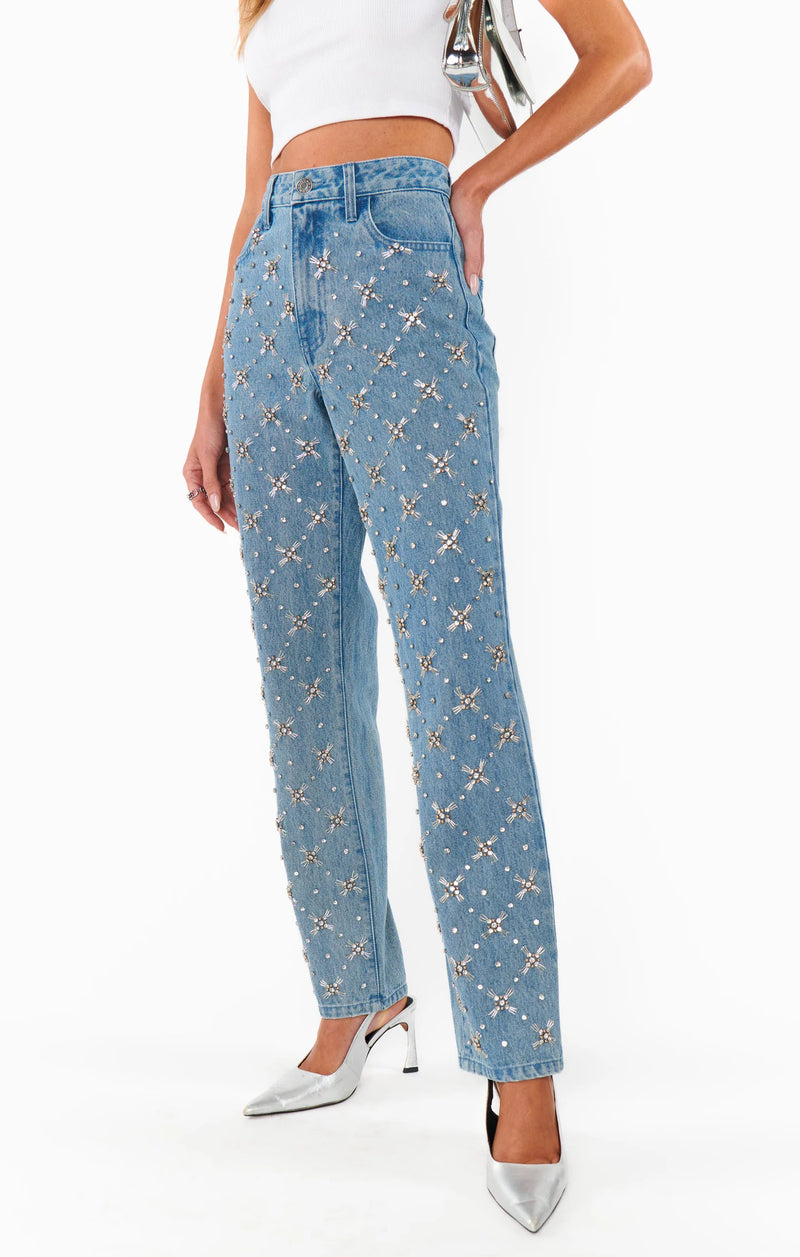 Blue jeans with star pattern worn by a person on a white background