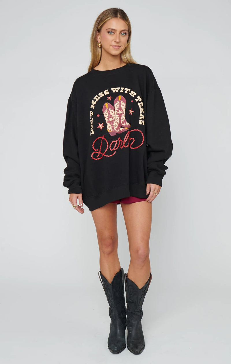 Woman wearing a black sweatshirt with a graphic design on a white background