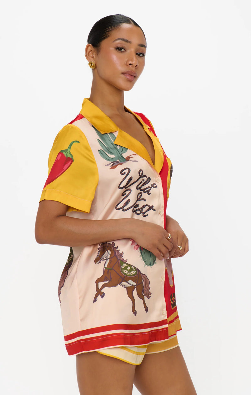 Woman wearing a colorful outfit with graphic designs on a white background
