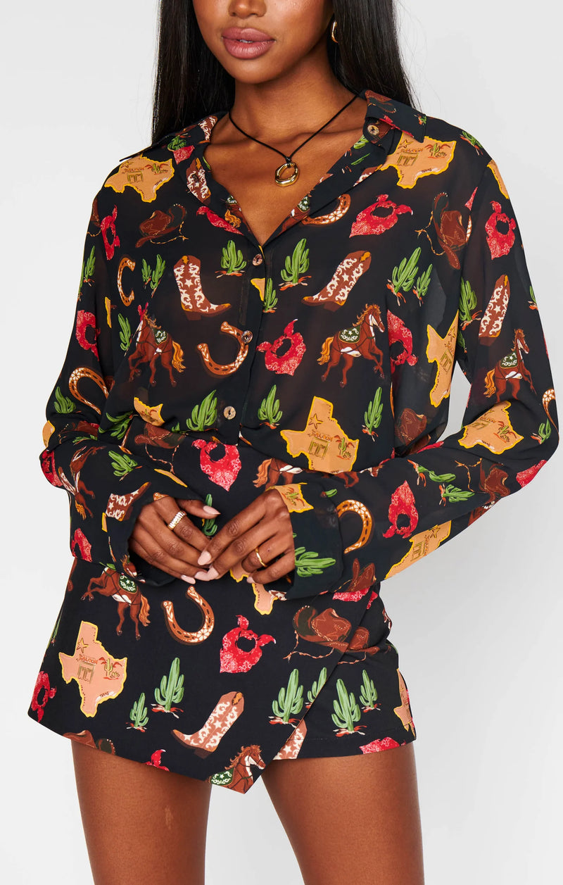 Woman wearing a black patterned outfit with colorful designs on a white background