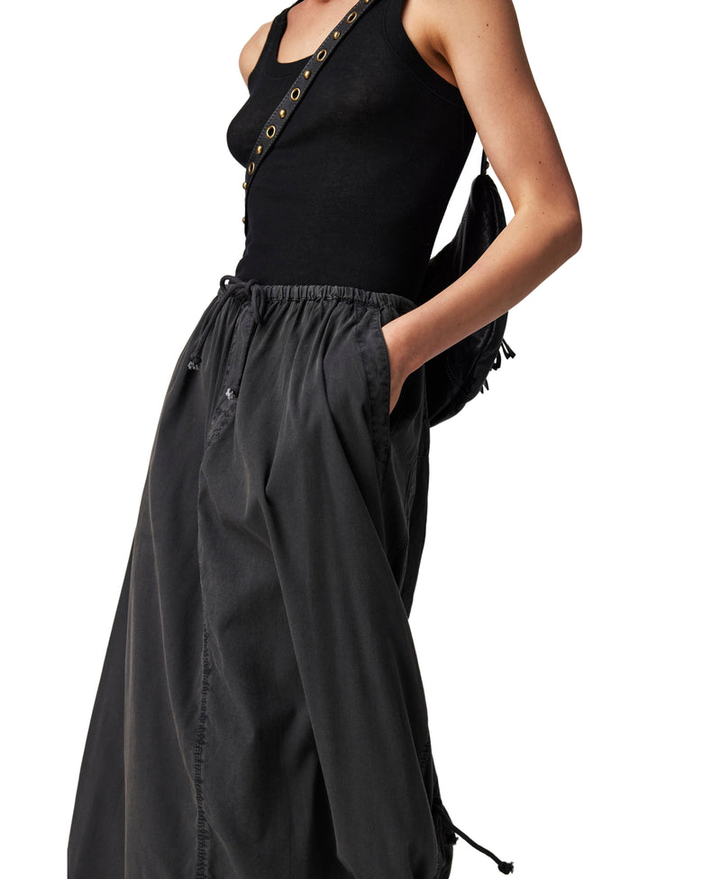Woman wearing black parachute maxi skirt with cinch feature at the top and the bottom