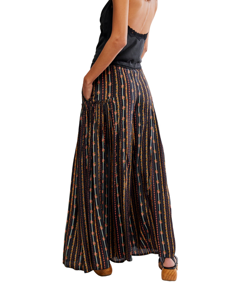 Person wearing a long, patterned skirt on a white background