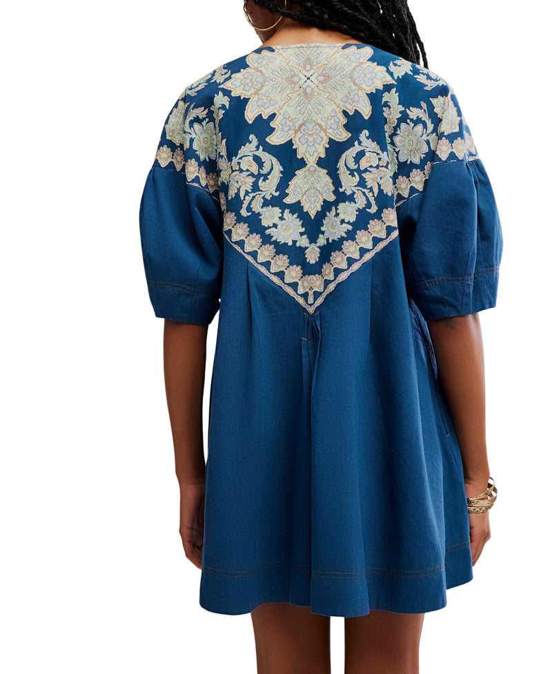 Blue dress with white floral embroidery on a white background