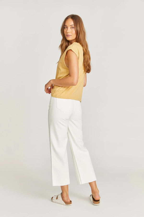 Woman wearing white cropped pants with flower cut outs on the bottom