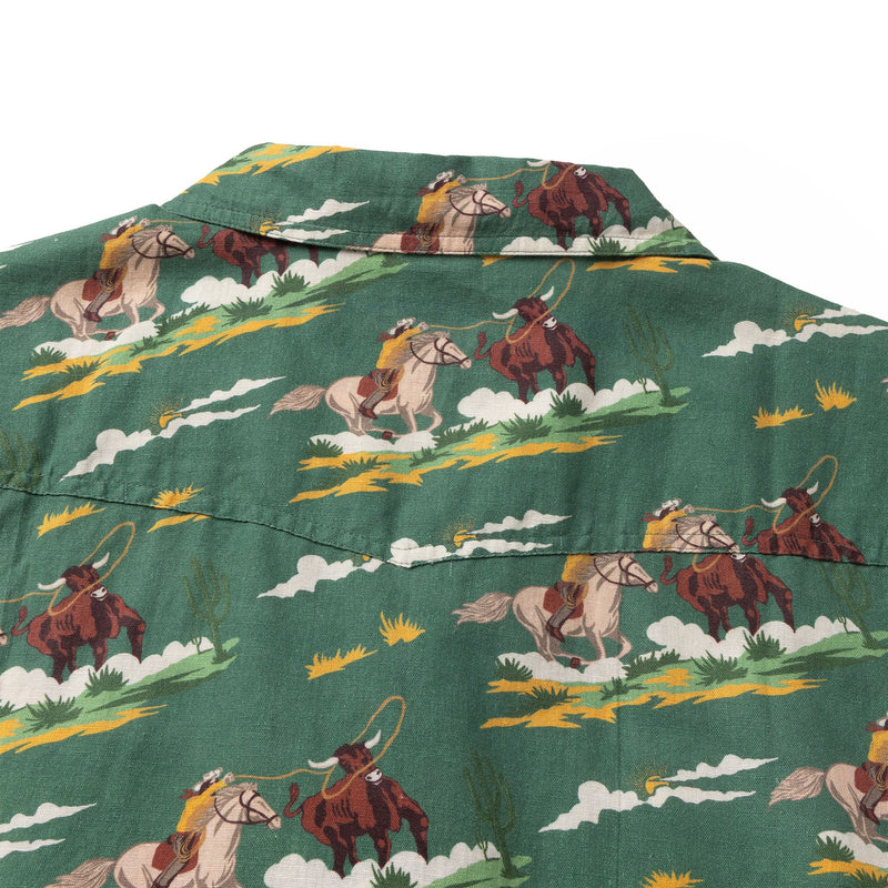 Green pearl snap shirt with double breast pockets and image of cowboy roping a steer repeated all over