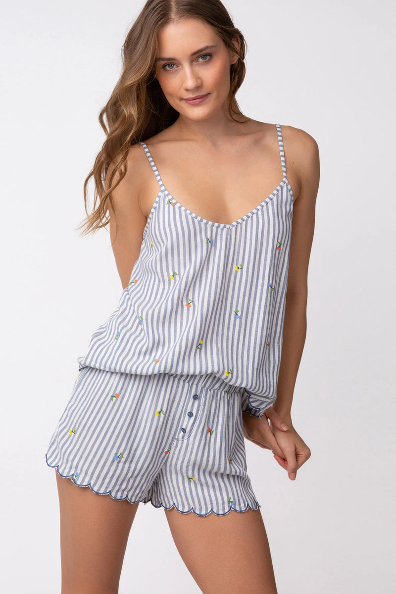 Woman wearing grey and white stripe pajama shorts with embroidered flowers all over and scallop hem detail