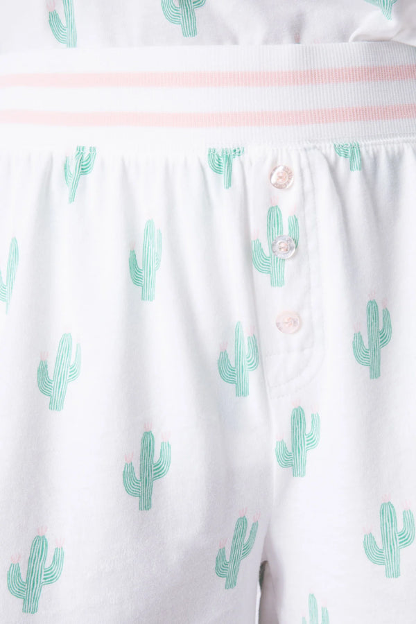 Woman wearing white sleep shorts with small green cacti all over