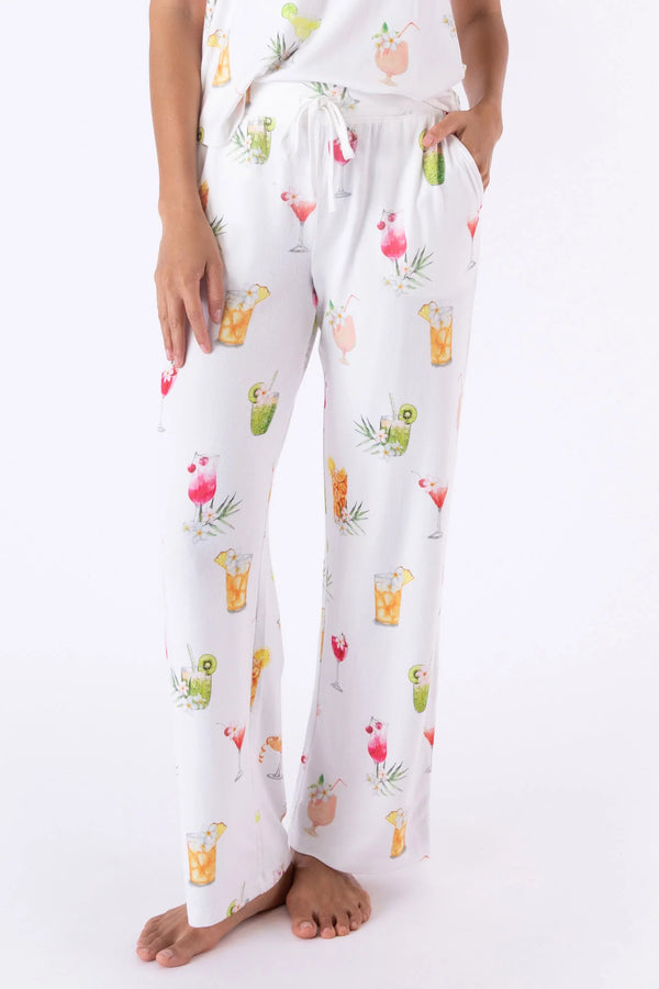 Woman wearing pajama pants with white background and vibrant cocktails throughout 