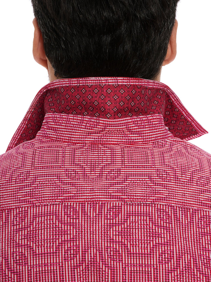 Man wearing pin and white short sleeve button up dress shirt with geometric pattern throughout
