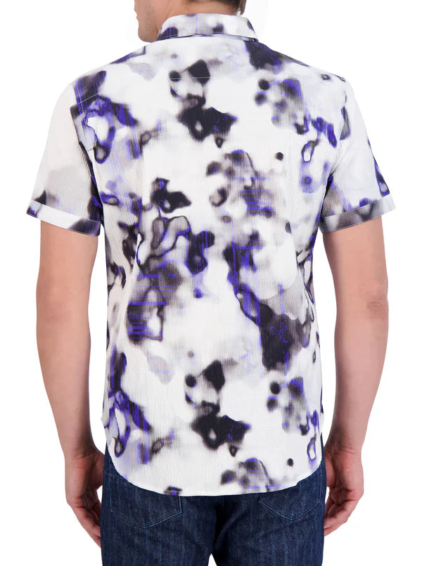 Man wearing short sleeve button up shirt with black and blue ink blot pattern