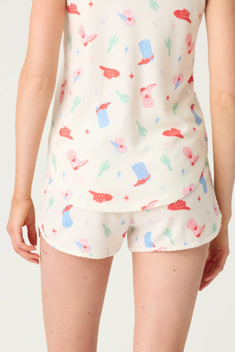 Person wearing a sleeveless top and shorts with colorful ice cream pattern on a plain background