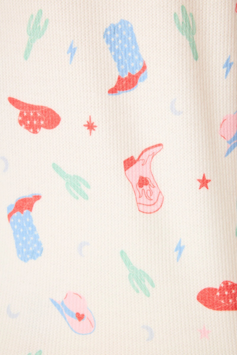 Pattern of cowboy boots, a saddle, and cacti on a beige background