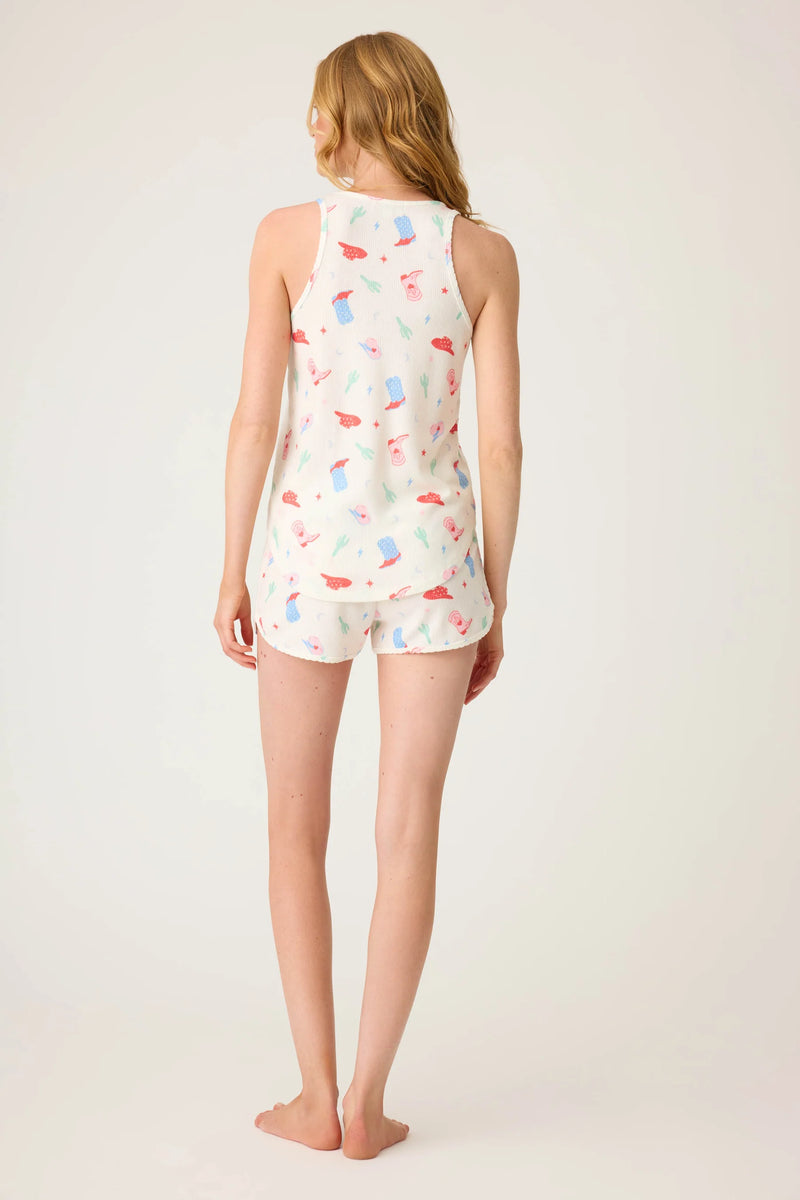Woman wearing a sleeveless romper with colorful abstract pattern on a plain background