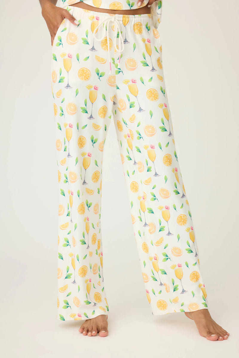 Lemon-patterned pajama pants worn by a person on a plain background