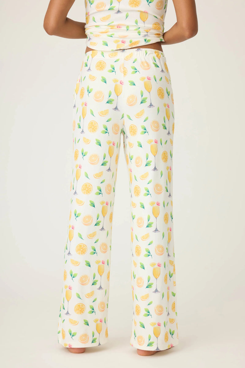 Person wearing a outfit with lemon patterned pants on a plain background