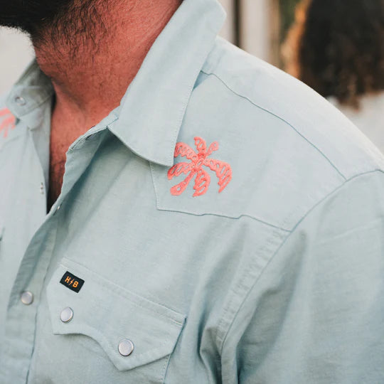 Men's short sleeve pearl snap shirt with pink embroidered palm trees near the shoulders