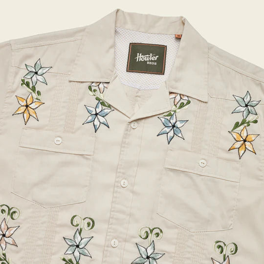 Short sleeve Hawaiian guayabera shirt with four pockets on the front with flowers in blue and orange flowers throughout