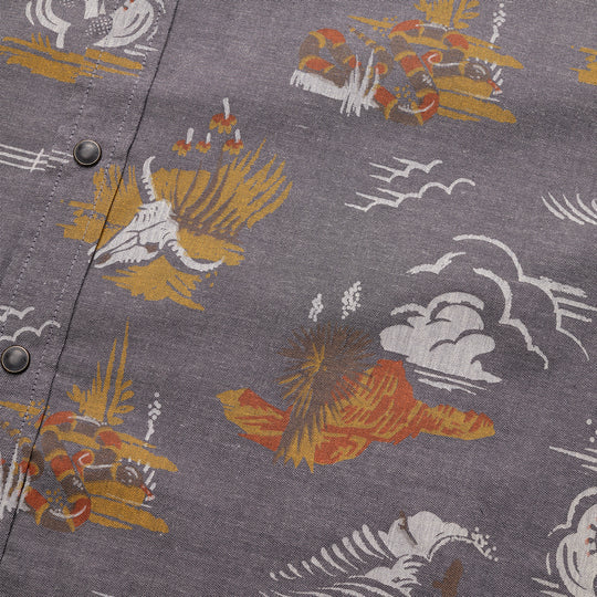 Grey short sleeve shirt with images of cow skill, canyon, wagon wheel and cacti in orange, yellow and hazel colorway