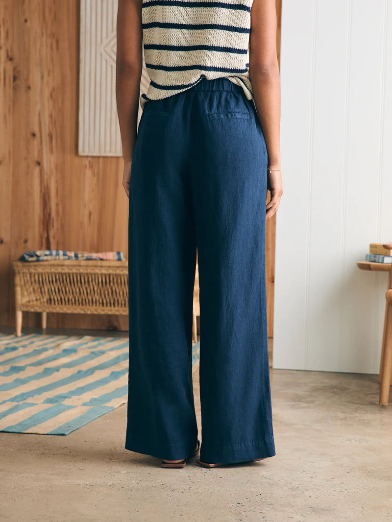 Woman wearing navy linen pant with elastic waist, pockets and wide leg detail