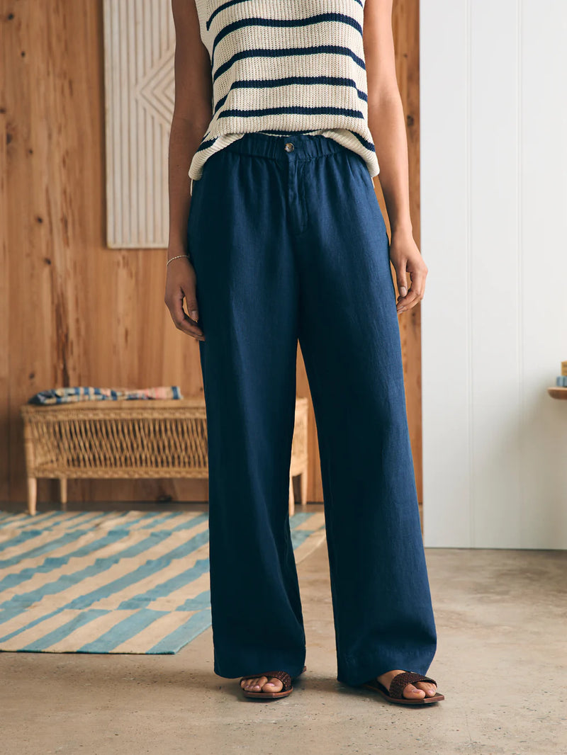 Woman wearing navy linen pant with elastic waist, pockets and wide leg detail
