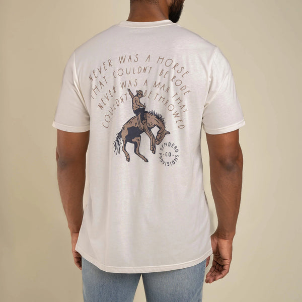 White short sleeve t-shirt with graphic of cartoon cowboy riding bronc with script behind that says "never was a horse that couldn't be rode never was a man that couldn't be throwed"