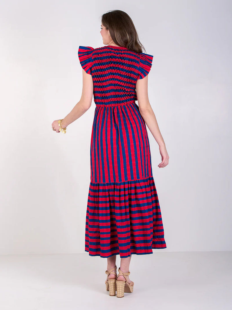 Woman wearing a red and blue striped dress on a white background