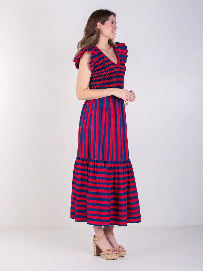 Woman wearing a red and blue striped dress against a white background
